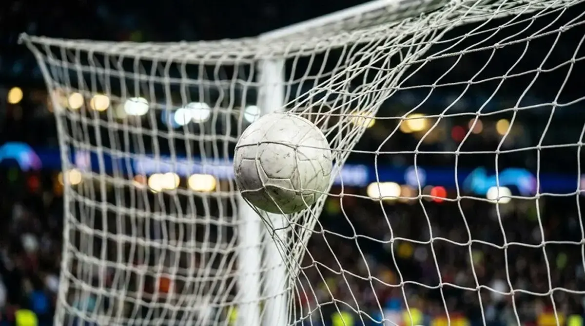 Dettaglio di un pallone che colpisce la rete sul fondo della porta, simbolo della sfida a eliminazione diretta